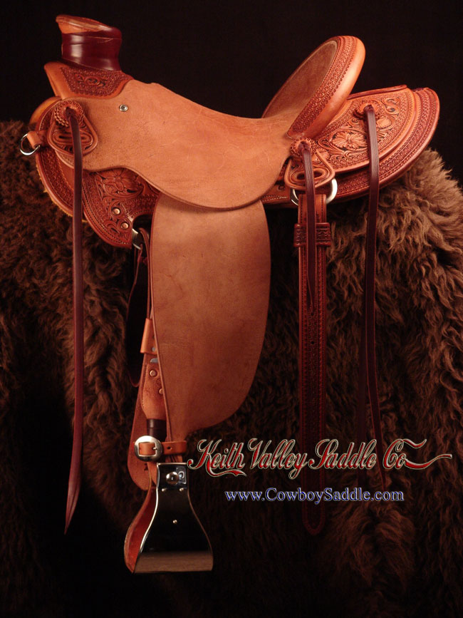 Douglas 38 Wade - tree, 15 and 1/4 inch seat, Gullet - 7 and 1/2 inch by 6 and 1/4 inch by 4 inch, Horn 3 inch round, 90 degree bars, 7/8ths flat palte riggin, Cheyenne Roll, Sheridan Style Floral Carving bordered with Vaquero Lace original design by Keith Valley.